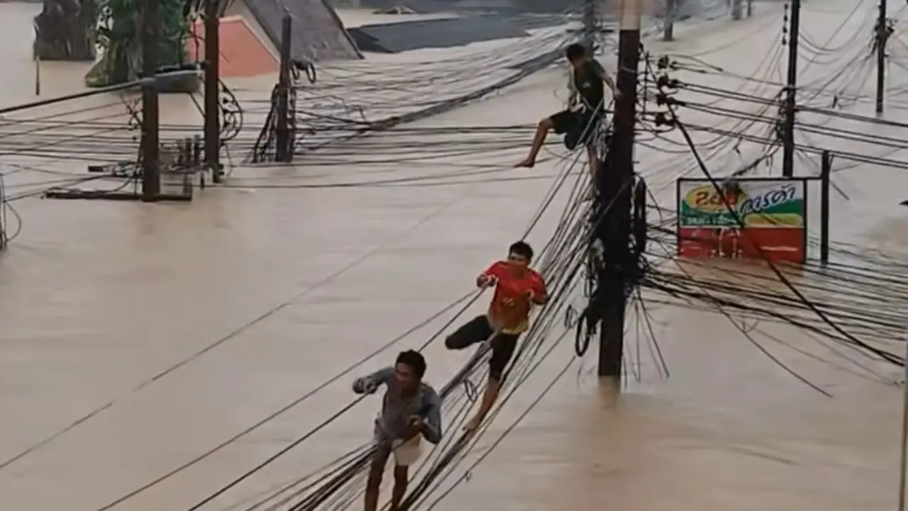 ไม่มีทางเลือก ชาวบ้านไต่สายไฟหนีน้ำท่วม บริเวณวัดพุทธิการาม ที่สงขลา